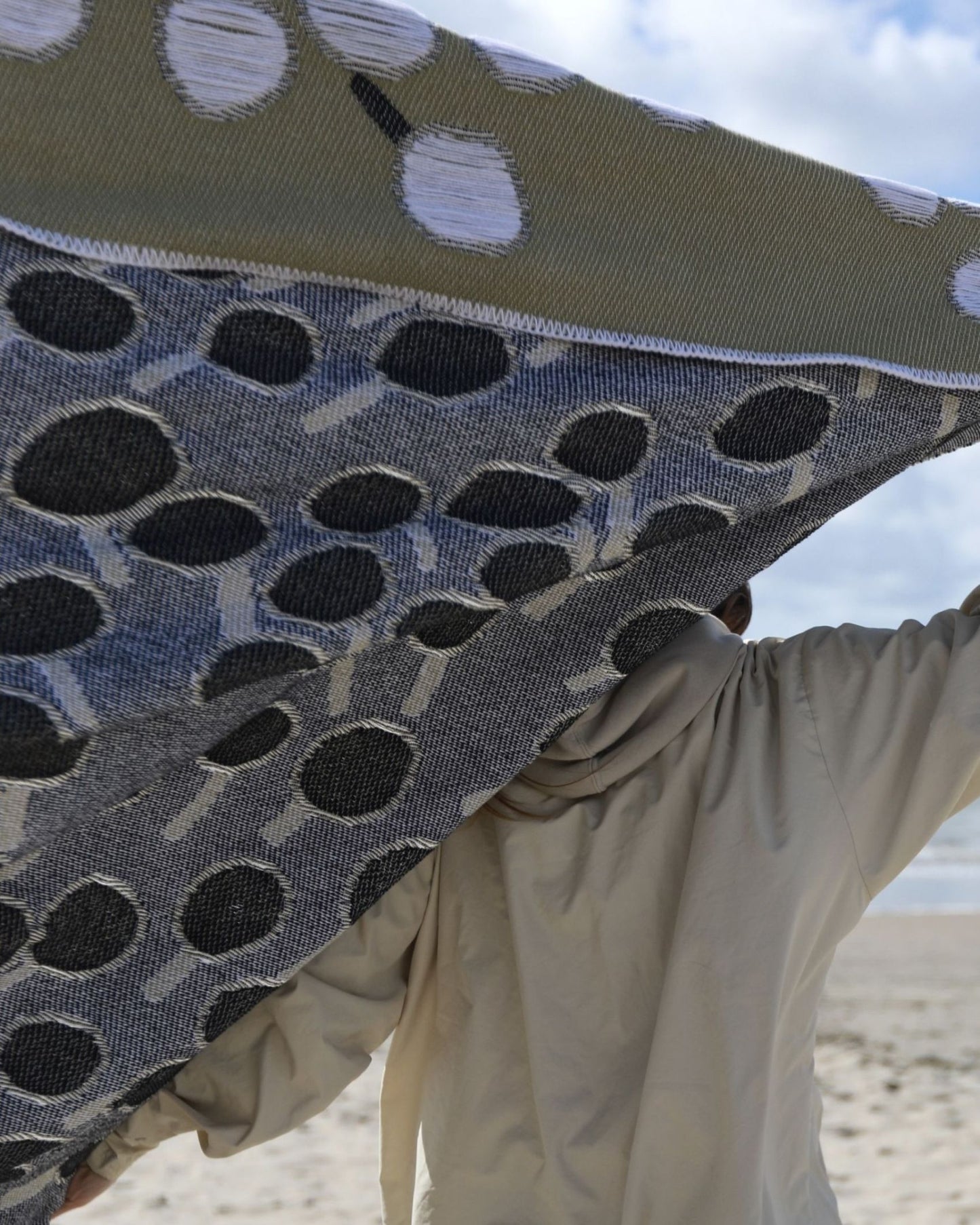 Closeup of back view of cotton blanket with dandelion pattern designed by Liucija Kostiva