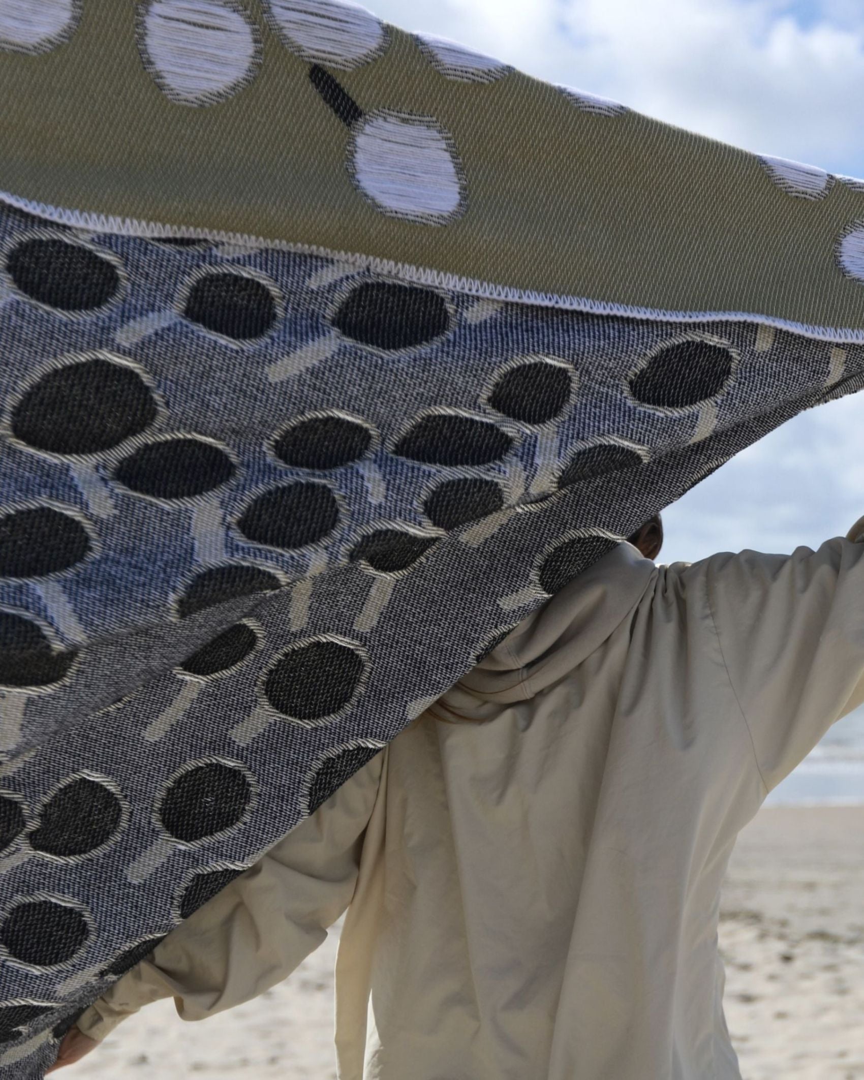 Closeup of back view of cotton blanket with dandelion pattern designed by Liucija Kostiva