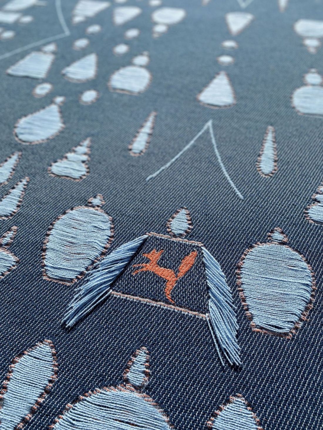 Cotton blanket close-up showing topiary garden and animals pattern, designed by Liucija Kostiva