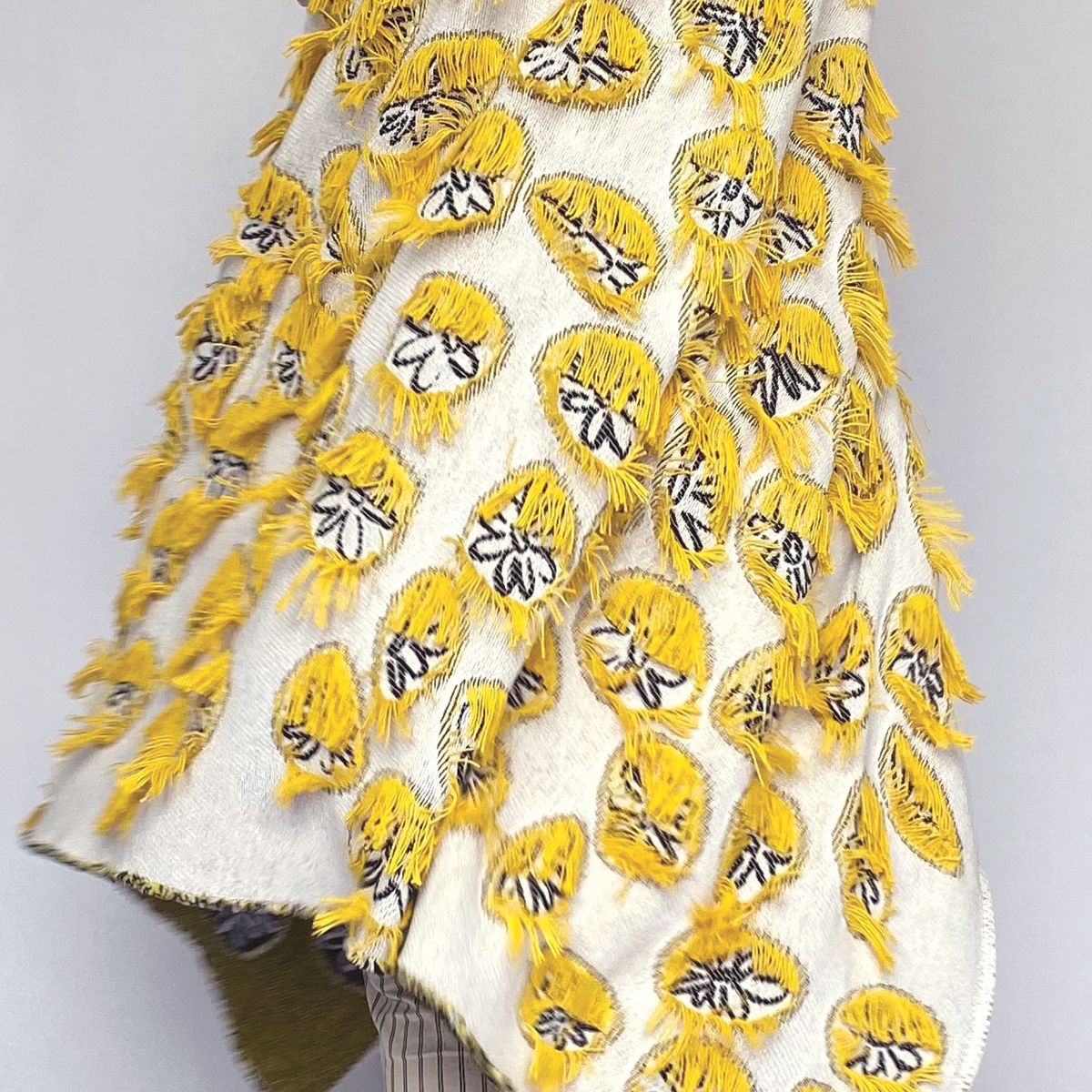 Detail of yellow and white cotton blanket with daisy pattern and fringes designed by Liucija Kostiva